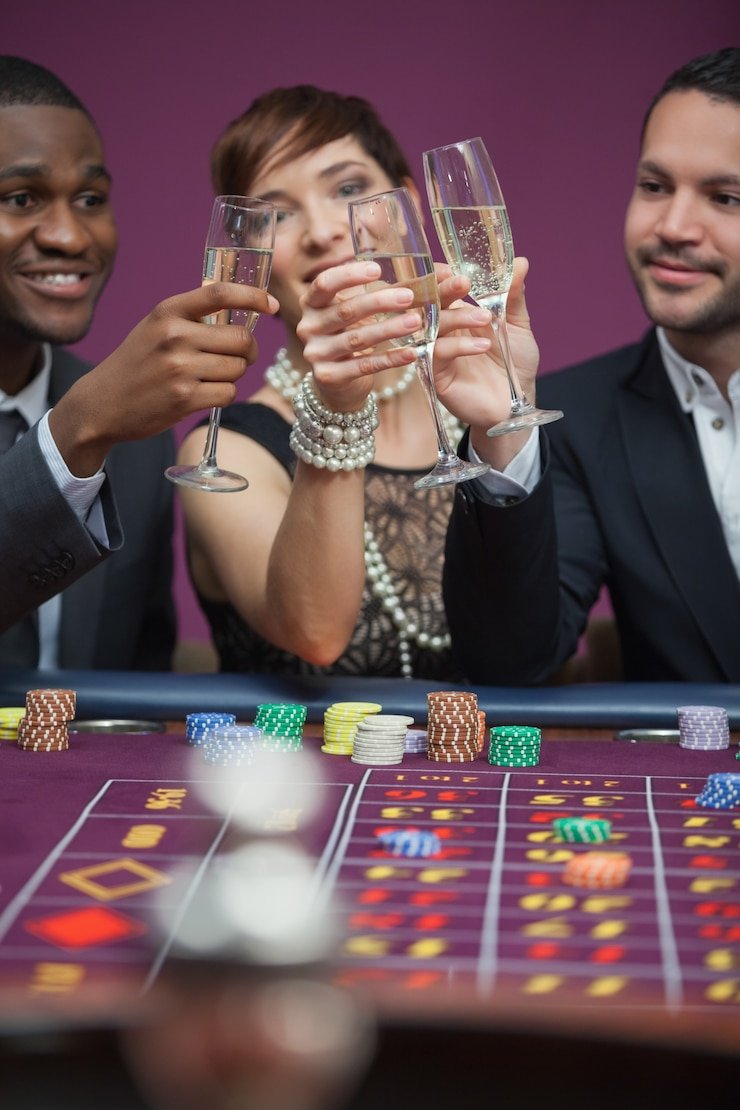 Meja baccarat dan roulette dengan chip dan kartu tersusun rapi menanti pemain